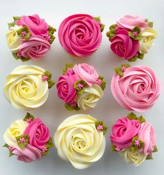 twelve cupcakes with pink and white frosting roses on each one, arranged in a circle