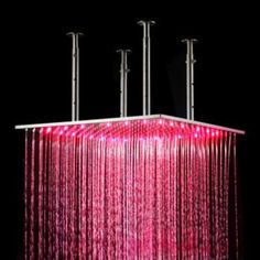 a pink chandelier hanging from the ceiling in front of a black background with three poles