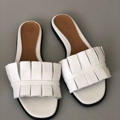 Pleated White Leather Sandals Luxury Summer Flats With Round Toe, Luxury Round Toe Flats For Summer, White Flat Sandals With Leather Sole, White Leather Open Toe Flats, Elegant Round Toe Slides For Vacation, Modern White Beach Mules, White Slides With Leather Sole For Summer, Chic White Sandals With Leather Sole, Chic White Flat Sandals