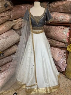 Jasmine white plain lehenga with gold border teamed with contrasting grey intricate in kundan, cut dana and stone work blouse and net dupatta. Fabric: Silk Occasion: Wedding Ceremony or Reception. WASH CARE INSTRUCTIONS - Please Dry clean only when it is applicable. Slight color variation is possible due to digital photography. This outfit can be customized in multiple colors and specific to client measurements. 120 days of production time is required and are for bulk orders only!Order are proce White Raw Silk Lehenga For Reception, Designer White Dola Silk Lehenga, White Dola Silk Lehenga For Designer Wear, Designer White Lehenga With Sheer Dupatta, White Raw Silk Choli For Wedding, White Raw Silk Floor-length Lehenga, Festive White Choli With Sheer Dupatta, White Floor-length Raw Silk Lehenga, White Dola Silk Lehenga With Zari Work