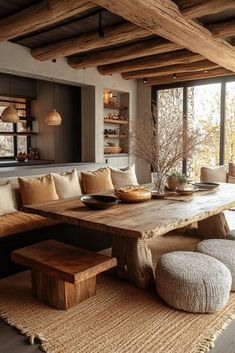 a large wooden table sitting in the middle of a living room next to a window