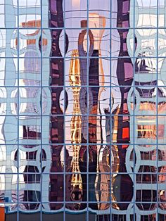 the reflection of buildings in an office building's glass facade is seen through it