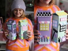 two girls are holding up some lego houses