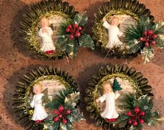 four christmas wreaths with angel figurines on them