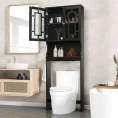 a white toilet sitting next to a bathroom sink under a mirror on top of a wooden shelf