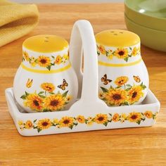 two sunflower salt and pepper shakers on a wooden table