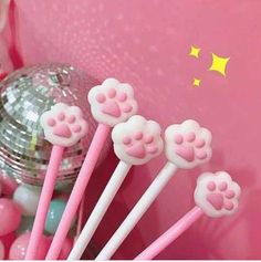 four pink and white cat paw lollipops in front of a disco ball