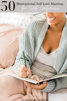 a woman sitting on a bed writing in a book with the title 60 affirmations that will change your life