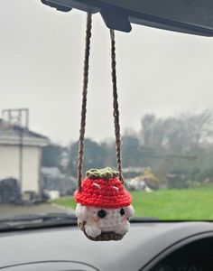 a small stuffed animal hanging from a car dashboard