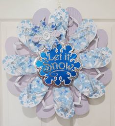 a blue and white flower with the words let it snow on it's center