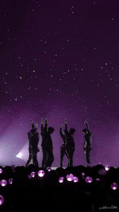 the silhouettes of four people standing in front of a purple sky with stars above them