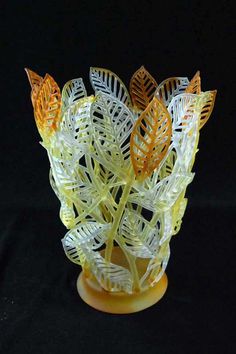 a glass vase that has been made to look like an abstract plant with leaves on it