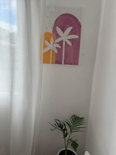 a potted plant sitting next to a window in a white walled room with curtains