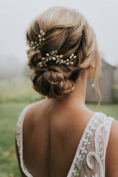 a woman in a wedding dress wearing a hair comb with pearls on the back of her head