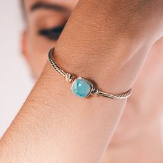 Indulge in the breathtaking beauty of nature with this exquisite larimar stone bracelet. Handcrafted with passion and attention to detail, featuring a smooth and polished 1cm larimar stone, this unique gemstone bracelet exudes a calming energy that will transport you to the turquoise waters of the tropics. These bracelets come in 2 sizes (Medium: 19 cm and Small: 17cm) The delicate, blue hues of the larimar stone are beautifully offset by the luxurious gold-plated bracelet, creating a stunning and timeless piece of jewelry that is sure to become a cherished favorite in your collection. The intricate design of the bracelet is a testament to the craftsmanship and skill of the artisan who created it, with each detail carefully considered to create a piece that is both elegant and striking. Bu Larimar Bracelet Jewelry Gift, Elegant Larimar Bracelet Jewelry, Turquoise Larimar Bracelet, Turquoise Larimar Bracelets As A Gift, Turquoise Larimar Bracelets For Gifts, Elegant Turquoise Larimar Bracelets, Turquoise Larimar Natural Stone Bracelets, Larimar Bracelet, Healing Stones Jewelry