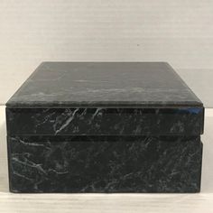 a black marble box sitting on top of a white table