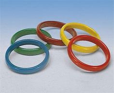 four different colored rubber rings on a white surface