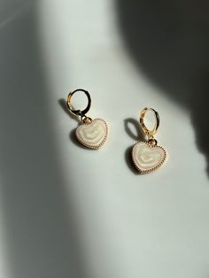 Améliorez votre jeu d'accessoires avec nos superbes créoles Huggie en plaqué or, dotées d'une breloque délicate en forme de cœur blanc. Ces boucles d'oreilles sont parfaites pour ajouter une touche d'élégance à n'importe quelle tenue, que vous vous habilliez pour une occasion spéciale ou que vous la gardiez décontractée. Détails du produit : Matériau : plaqué or de haute qualité pour une finition luxueuse. Hypoallergénique Modèle : cerceau classique avec un charmant pendentif coeur blanc Dimensi Dainty Hoop Earrings, Heart Dangle Earrings, Cute Heart, Love Charms, Huggie Hoop Earrings, White Heart, Gold Plating, Heart Charm, Heart Pendant