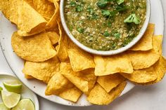 a white plate topped with chips and guacamole