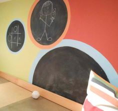 a child's room painted with colorful circles and chalk drawings on the wall, along with a stuffed animal