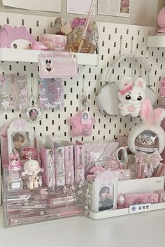 there are many items on the shelf in this room and it is pink, white and grey