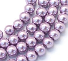 three strands of purple pearls on a white background