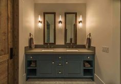 a bathroom with double sinks and two mirrors