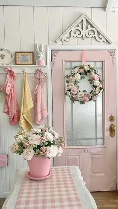 a pink potted plant sitting on top of a table next to a white door