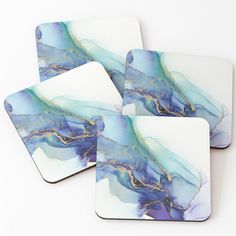 four coasters with blue and gold designs on them, one has a marble pattern