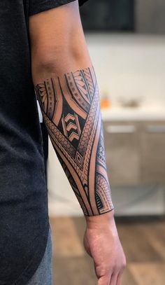 a man with a black and grey tattoo on his arm