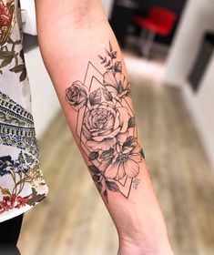 a woman's arm with a flower tattoo on the left side of her arm