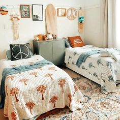 two beds in a bedroom with surfboards on the wall and rugs around them