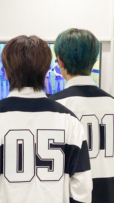 two young men standing next to each other in front of a flat screen tv with the number 205 on it