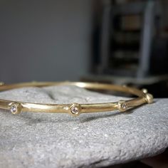 Handcrafted in solid 18k gold, the raw organic texture of this beautiful diamond bangle is contrasted by the brilliant sparkle of white diamonds.  The amorphic little globules are each set with a white 2 point vvs diamond. This diamond bracelet is beautiful by itself, and can also be worn with other bangles in a stack. This bracelet can be ordered without the diamonds, as seen in the last two pictures. Ask me for a quote. Dimensions: > The thickness of the bracelet is about 3 mm  > The inside di Elegant Hand Forged Yellow Gold Bangle, Heirloom Bracelet With Single Cut Diamonds For Anniversary, Heirloom Bracelets With Single Cut Diamonds For Anniversary, Heirloom Yellow Gold Bracelet With Diamond Accents, Anniversary Jewelry Bracelet With Single Cut Diamonds, Elegant Hand-forged Yellow Gold Bracelet, Fine Jewelry Bezel Setting Bracelets For Anniversary, Fine Jewelry Bracelets With Bezel Setting For Anniversary, Elegant Gold Hand Forged Bangle