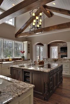 a large kitchen with marble counter tops and an island in the middle of the room