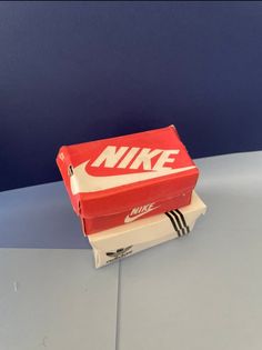 a red and white nike shoe box sitting on top of a counter next to a blue wall