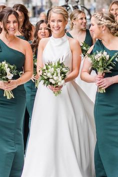 the bride and her bridesmaids are all dressed in green dresses with white flowers