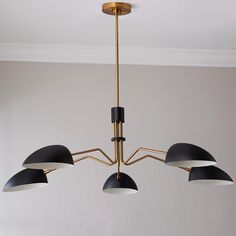 a chandelier with five lights hanging from it's sides in a room