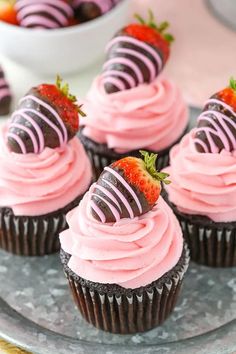 chocolate cupcakes with pink frosting and strawberries on top