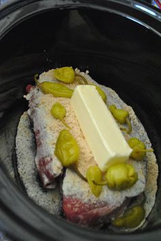 a crock pot filled with pickles, cheese and bread on top of it