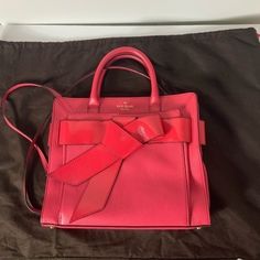 Gorgeous Kate Spade Bow Valley Rosa Satchel Handbag. Shoulder Bag Or Crossbody Strap. Ringwald Pink Leather. Comes With Dust Bag. Purse Is In Overall Very Good Condition. There Are Some Dark Spots That Are Not Very Noticeable On The Body Of The Purse (Circled) And Some Dark Spots And A Couple Small Flaws On The Handles. There Are Some Creases In Patent Leather To Front And Back Strap That Goes Around. The Patent Leather On The Edges Has Some Creases And A Couple Areas Where It Is Beginning To Sp