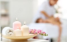 candles and towels on a table with a man in the background at spa or beauty salon