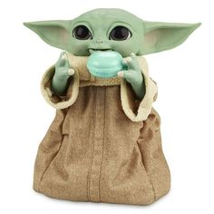 the child yoda toy is holding a bottle