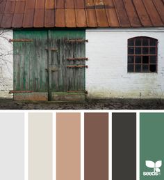 an old white building with green doors and brown roof