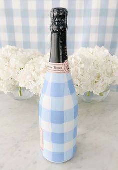 a blue and white gingham wine bottle sitting on top of a marble counter