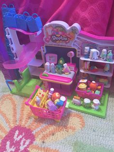 there is a toy kitchen set in the playroom with food and toys on the floor