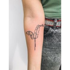 a woman's arm with a tattoo on it that has a banana and leaves