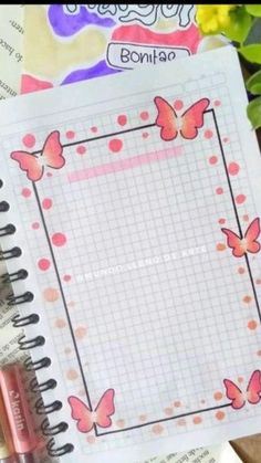 an open notebook with pink butterflies on it