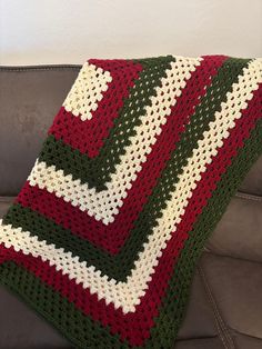 a crocheted blanket sitting on top of a couch