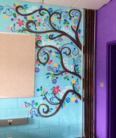 the bathroom is decorated in bright colors and has a tree painted on the wall next to it